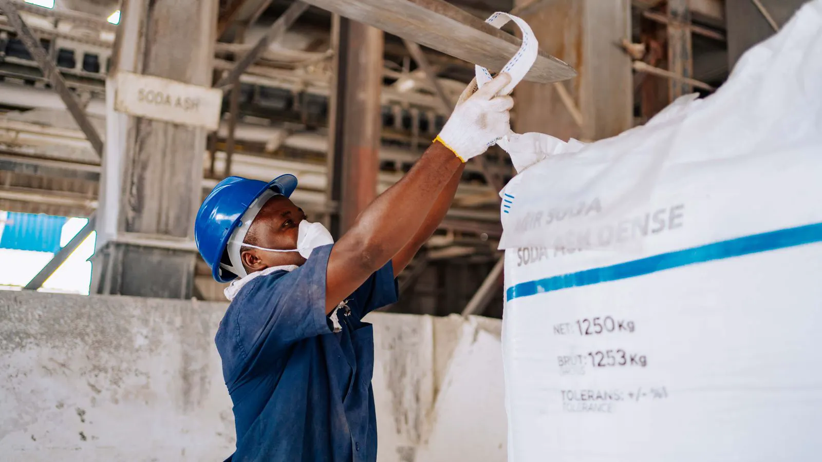 Workers inspecting bag components on a production line