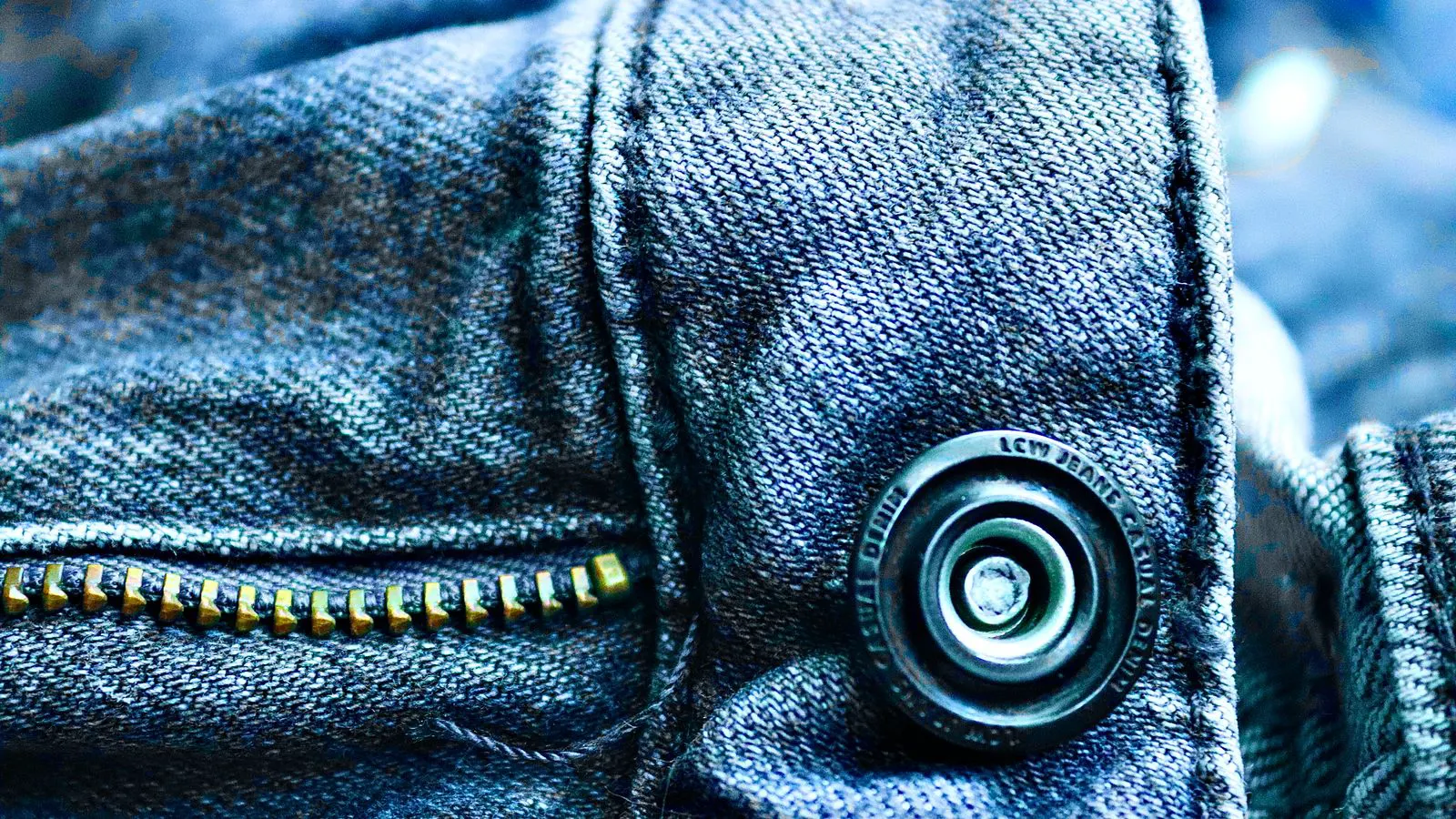 Close up of a metal zipper pull on a leather bag panel