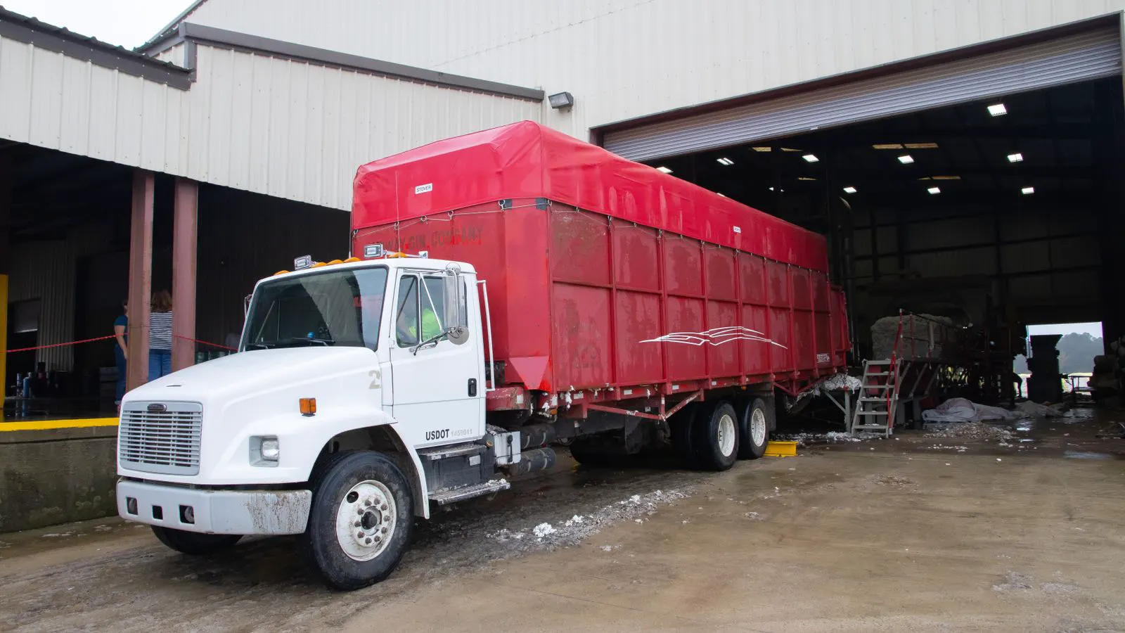 A freight container being lifted onto a truck at a port