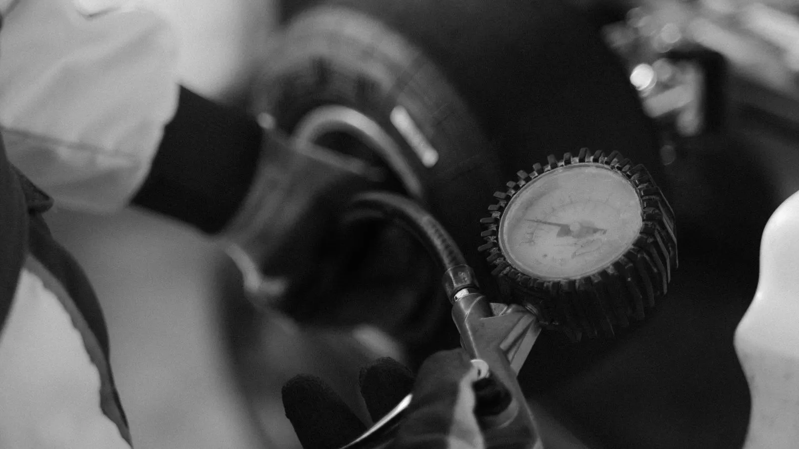 A digital gauge attached to a tire valve on a heavy vehicle.