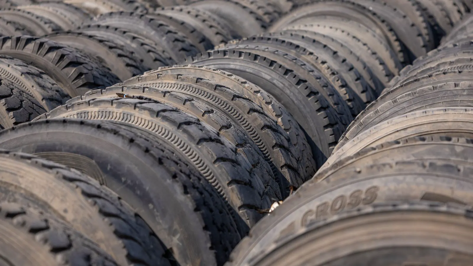A hand pointing to the tire sidewall label during inspection