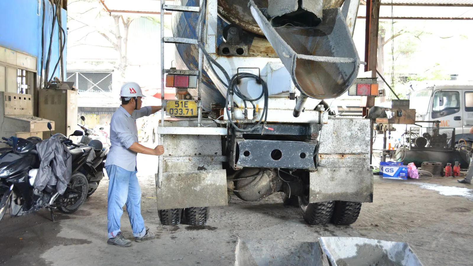 Technician inspecting a commercial truck tire tread depth with a gauge.