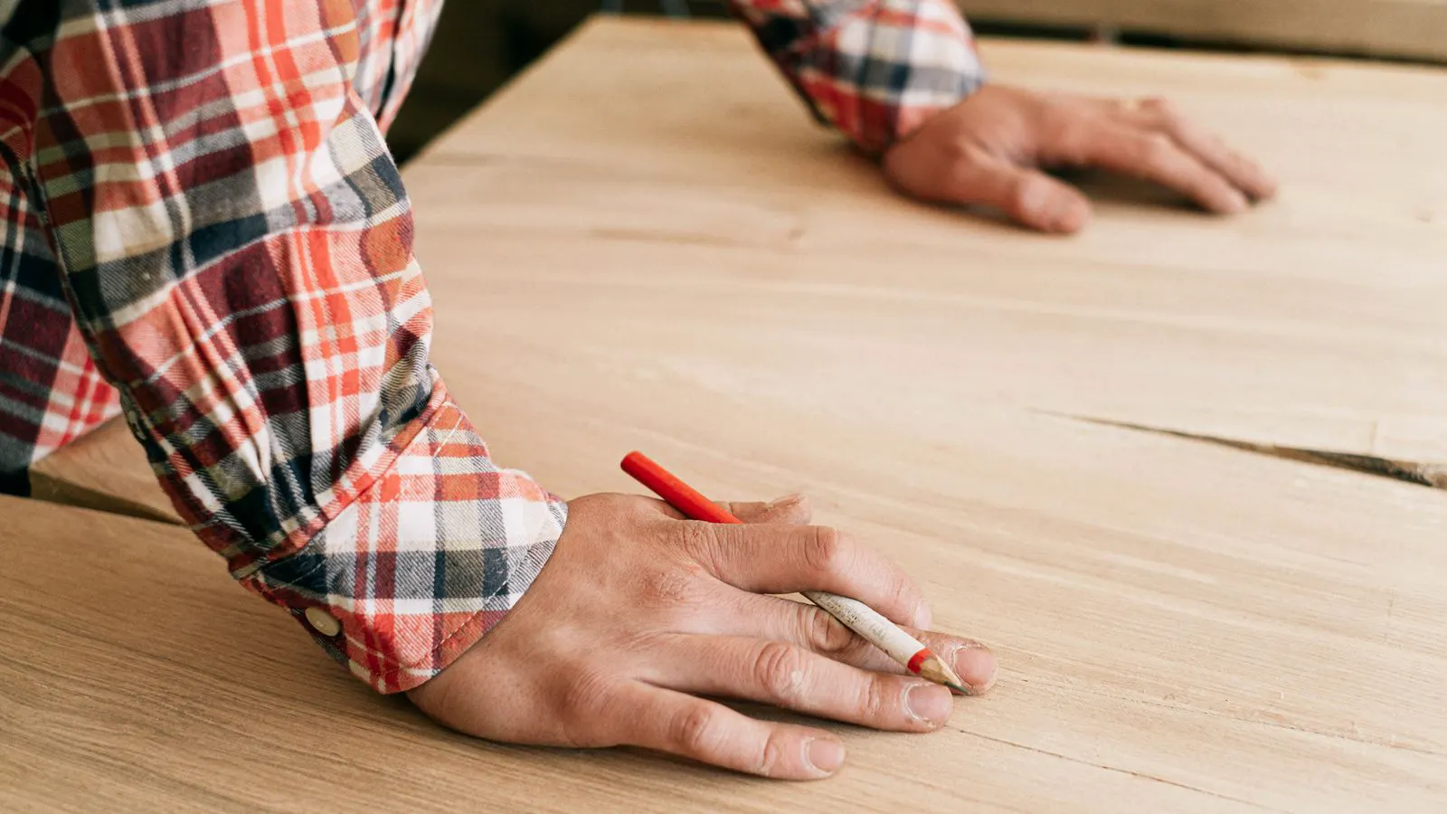 A close up of a flat veneer sheet next to a solid wood plank.