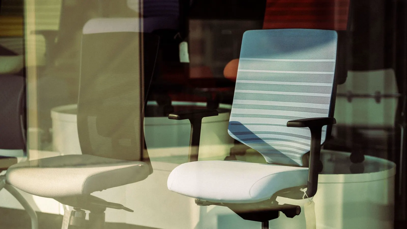 Person adjusting height and armrests of a mesh office chair