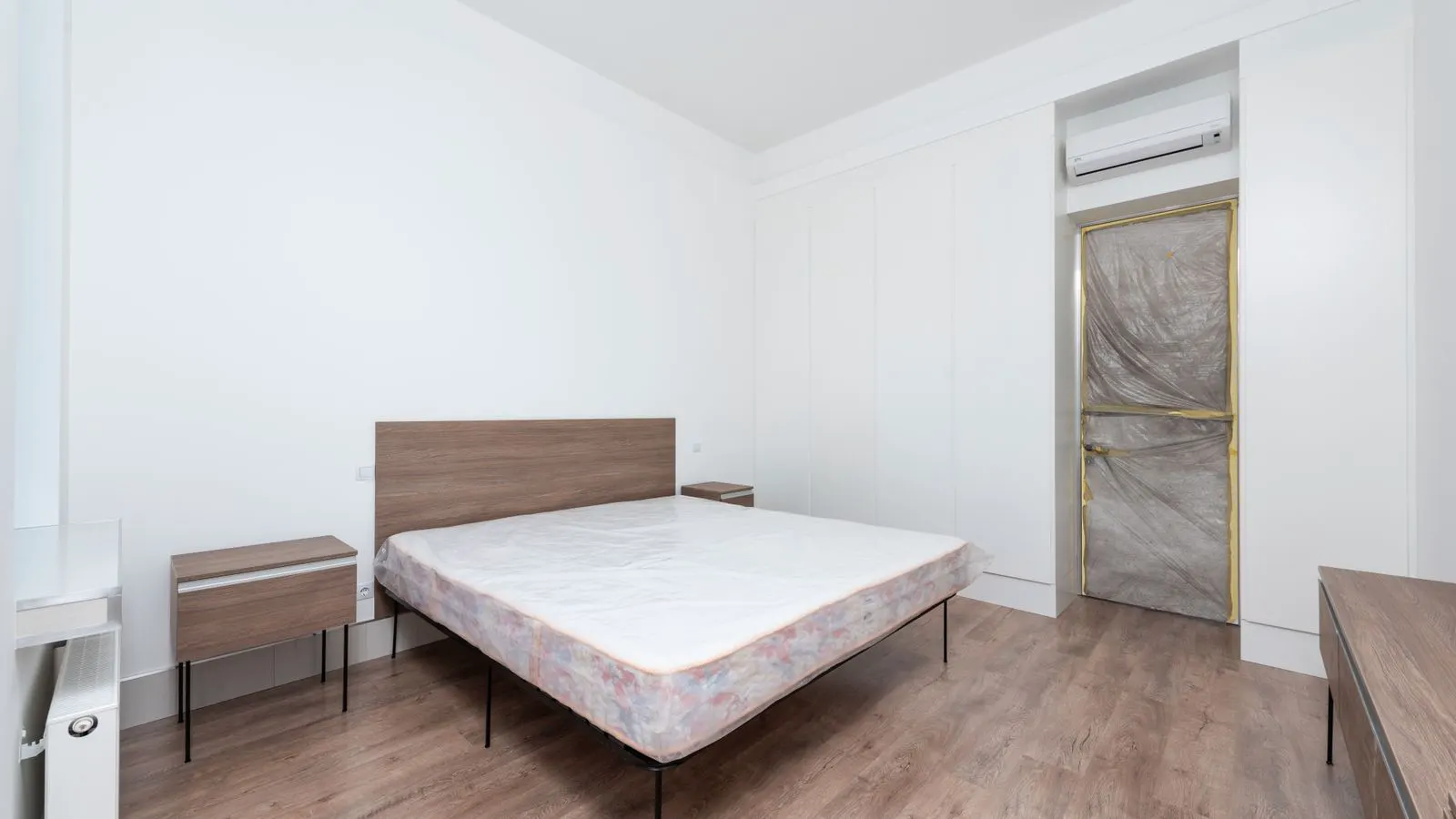 A partially assembled wooden bed frame showing slats and rails