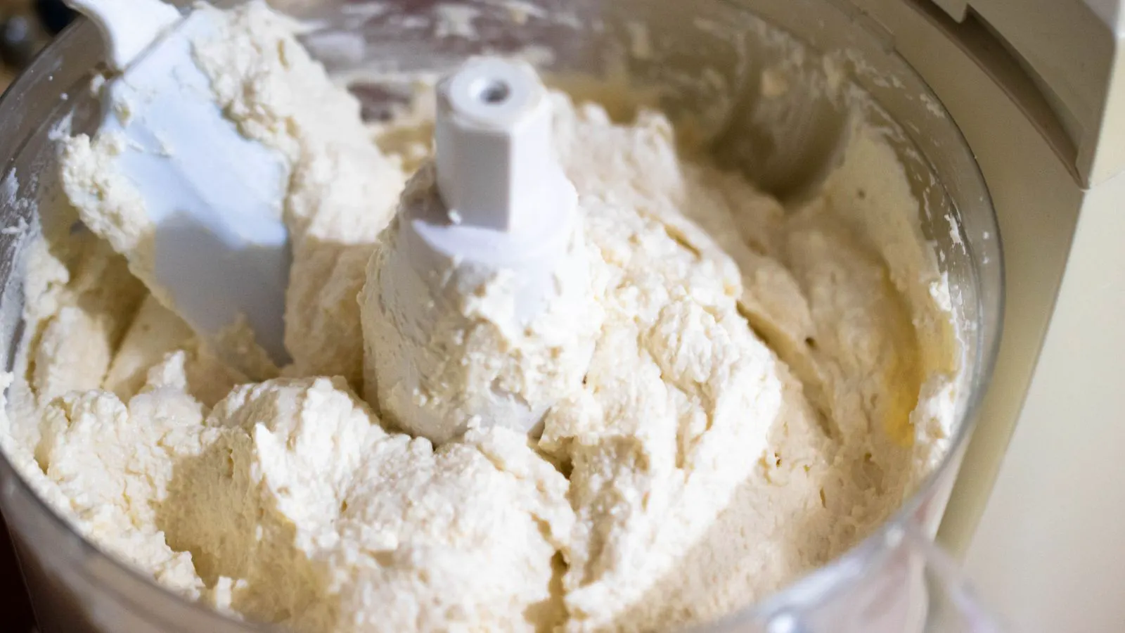 A professional food processor with a blade guard and safety interlock switch.