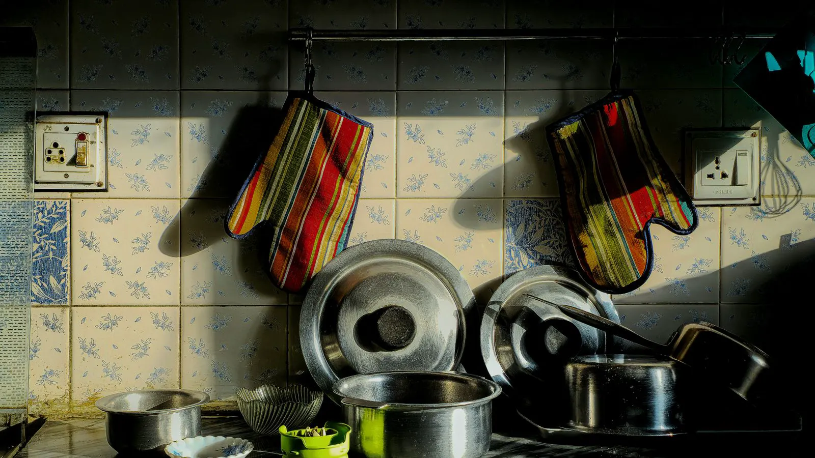 Stainless steel cookware pots arranged in a row on a factory floor