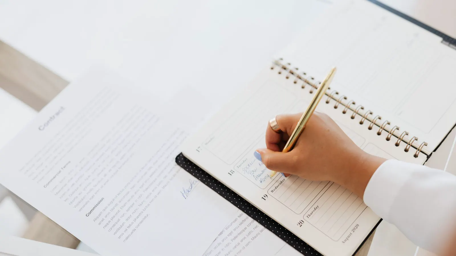 A planner reviewing budget sheets and equipment specs at a commercial kitchen workstation.