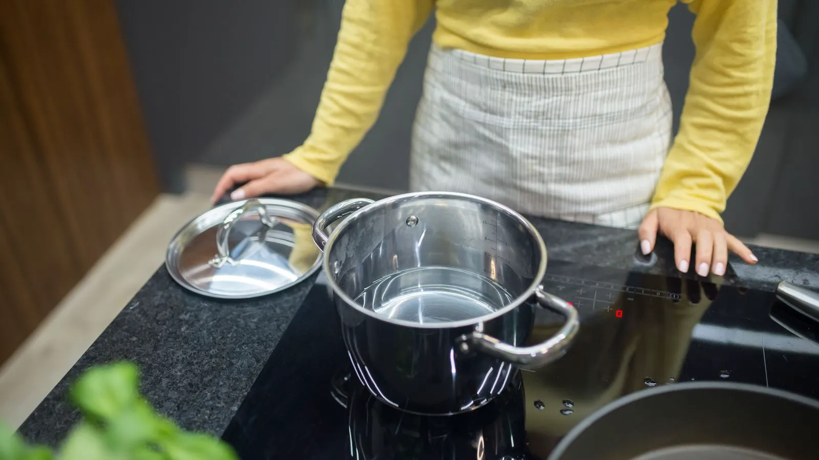 Stainless steel induction cooktop integrated into a commercial kitchen line