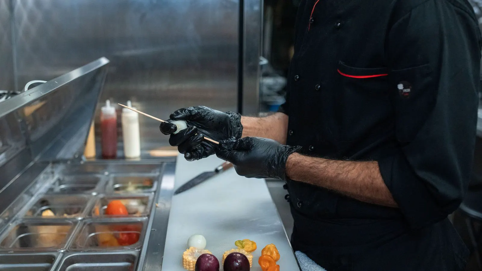 A technician inspecting a commercial kitchen refrigerator unit