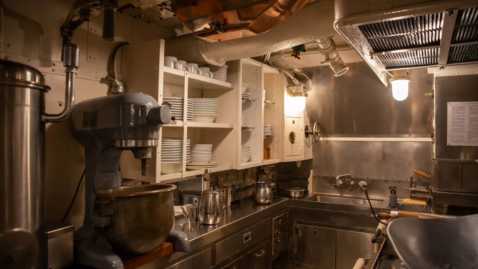 A stainless steel fryer with bubbling oil in a commercial kitchen setting