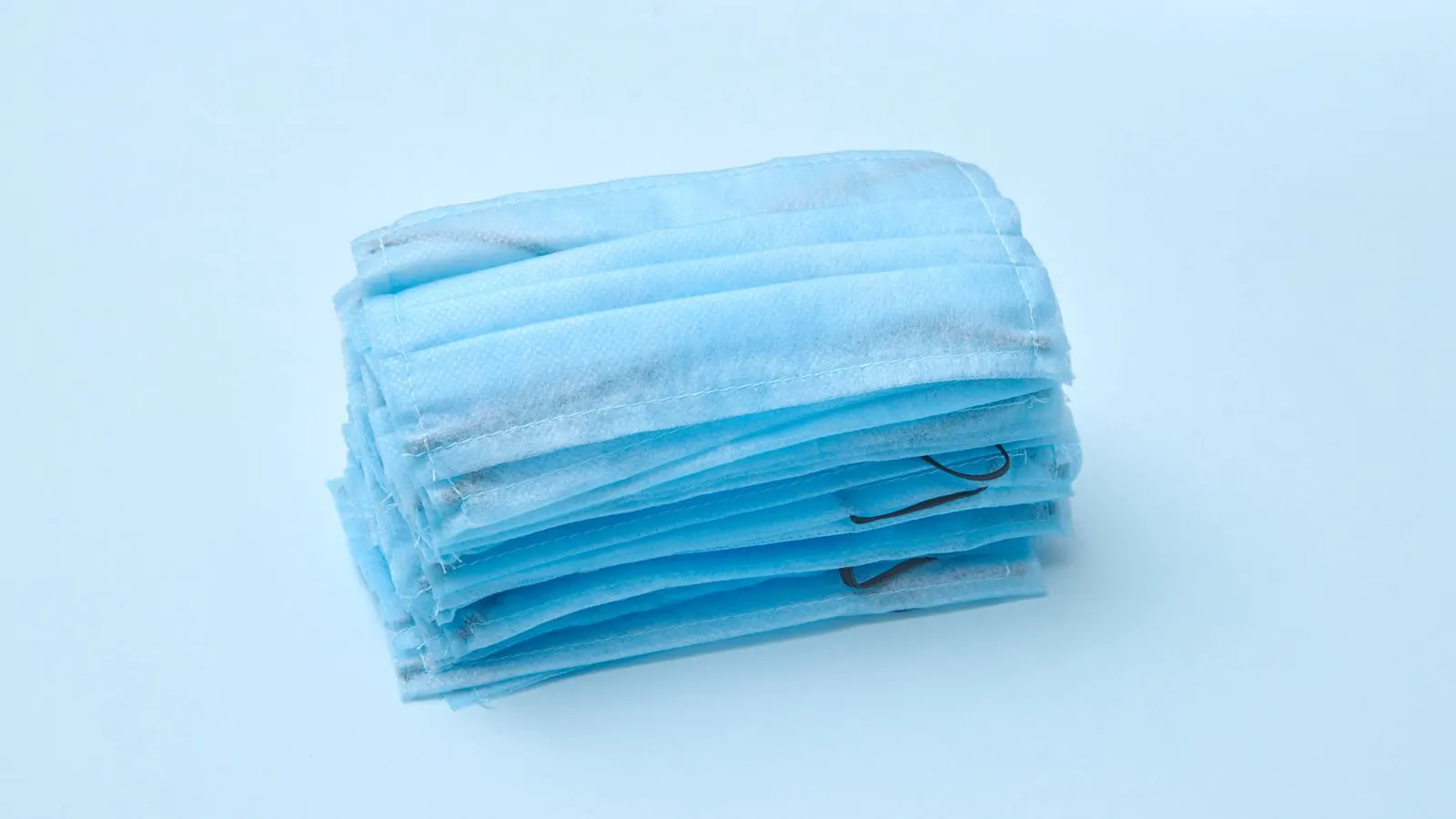 A close-up view of a modern surgical mask with visible filtration layers