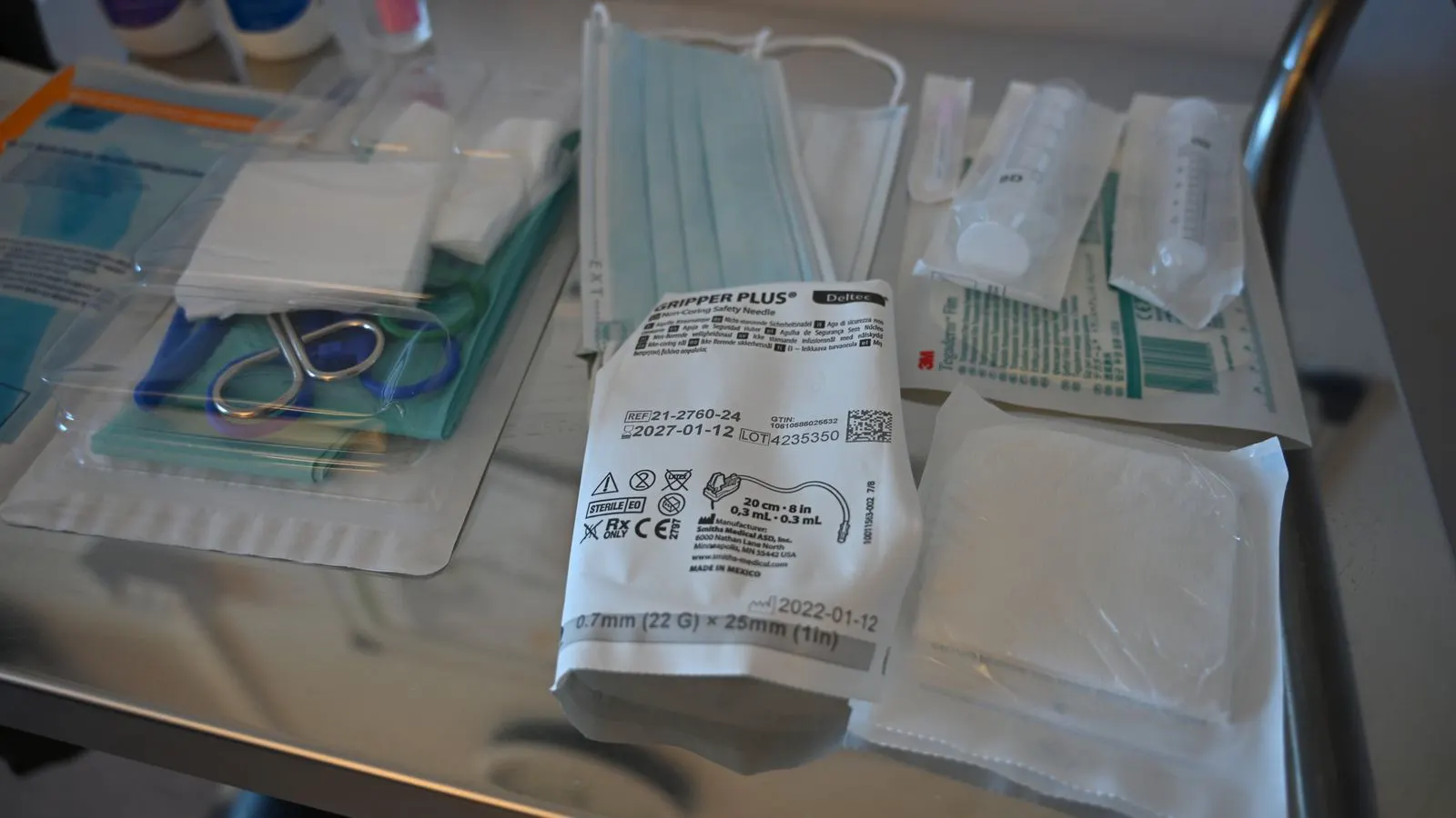 A table of wound care supplies including gauze pads and adhesive bandages