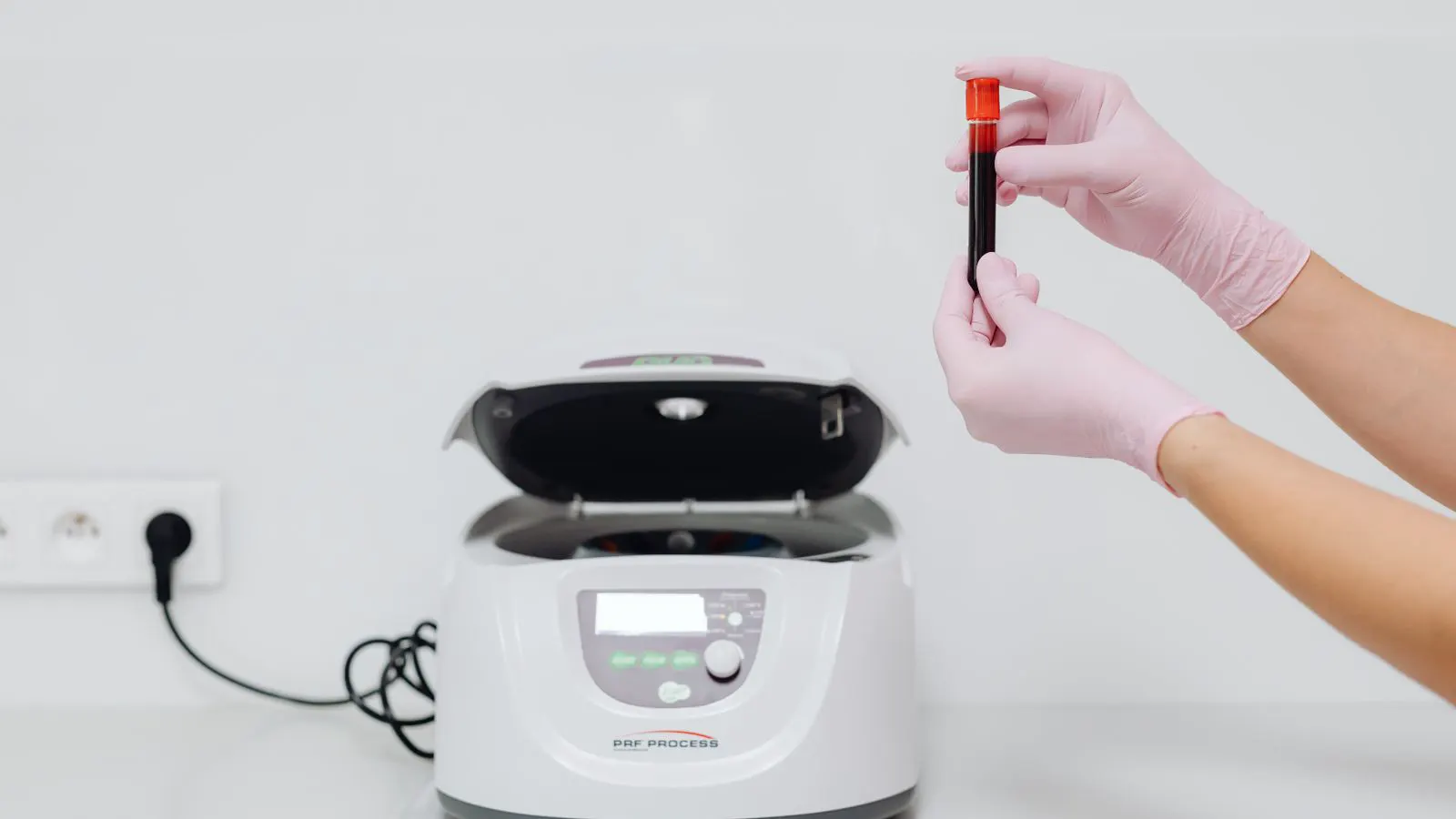 A technician uses a calibrated testing instrument in a clean laboratory environment.