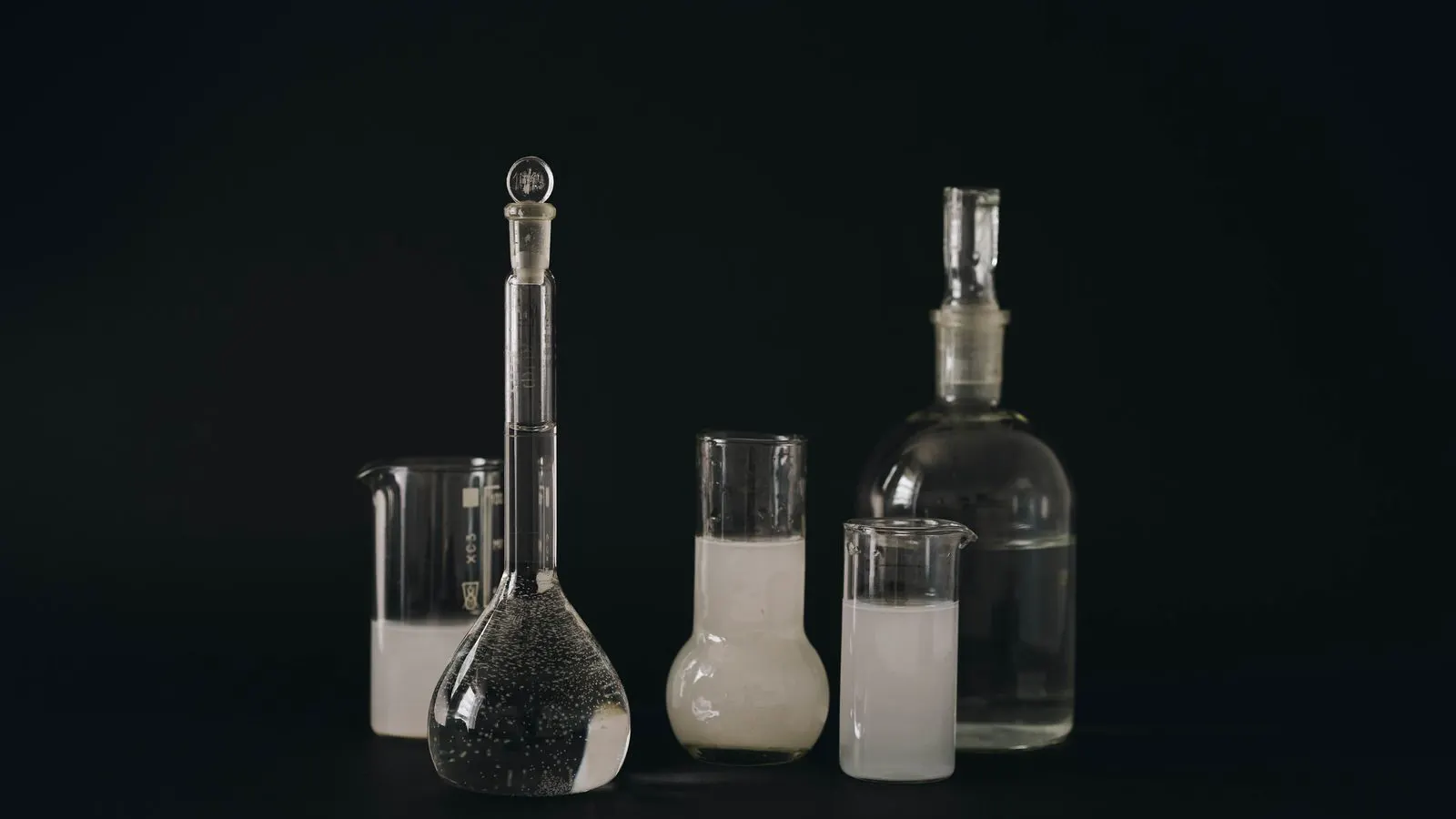 Organized lab shelf holding glass bottles and cardboard boxes