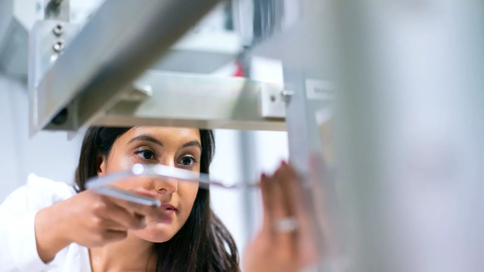 An engineer checks the calibration label on a laboratory analyzer.