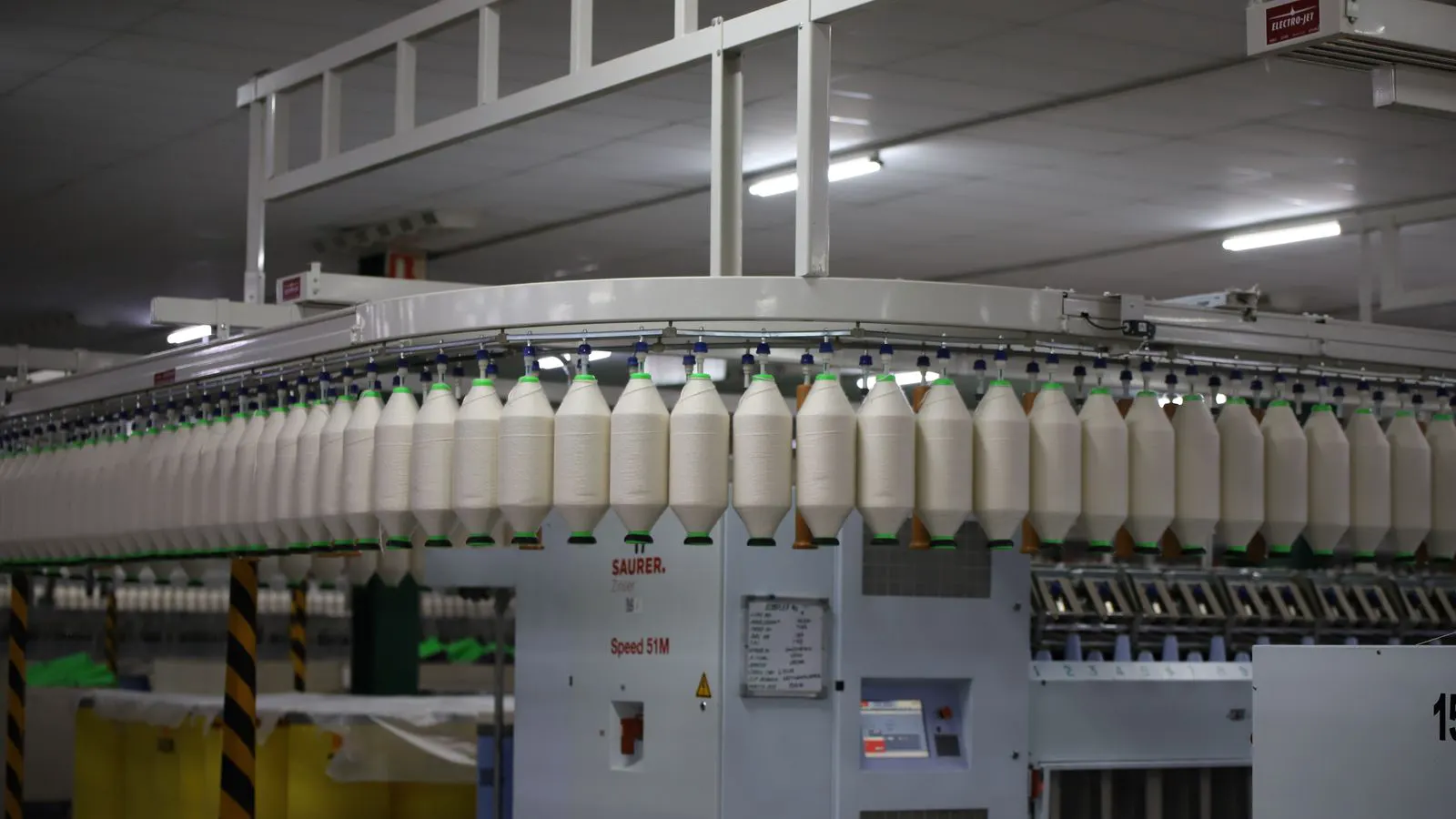 A clean factory floor with bottles and production equipment.