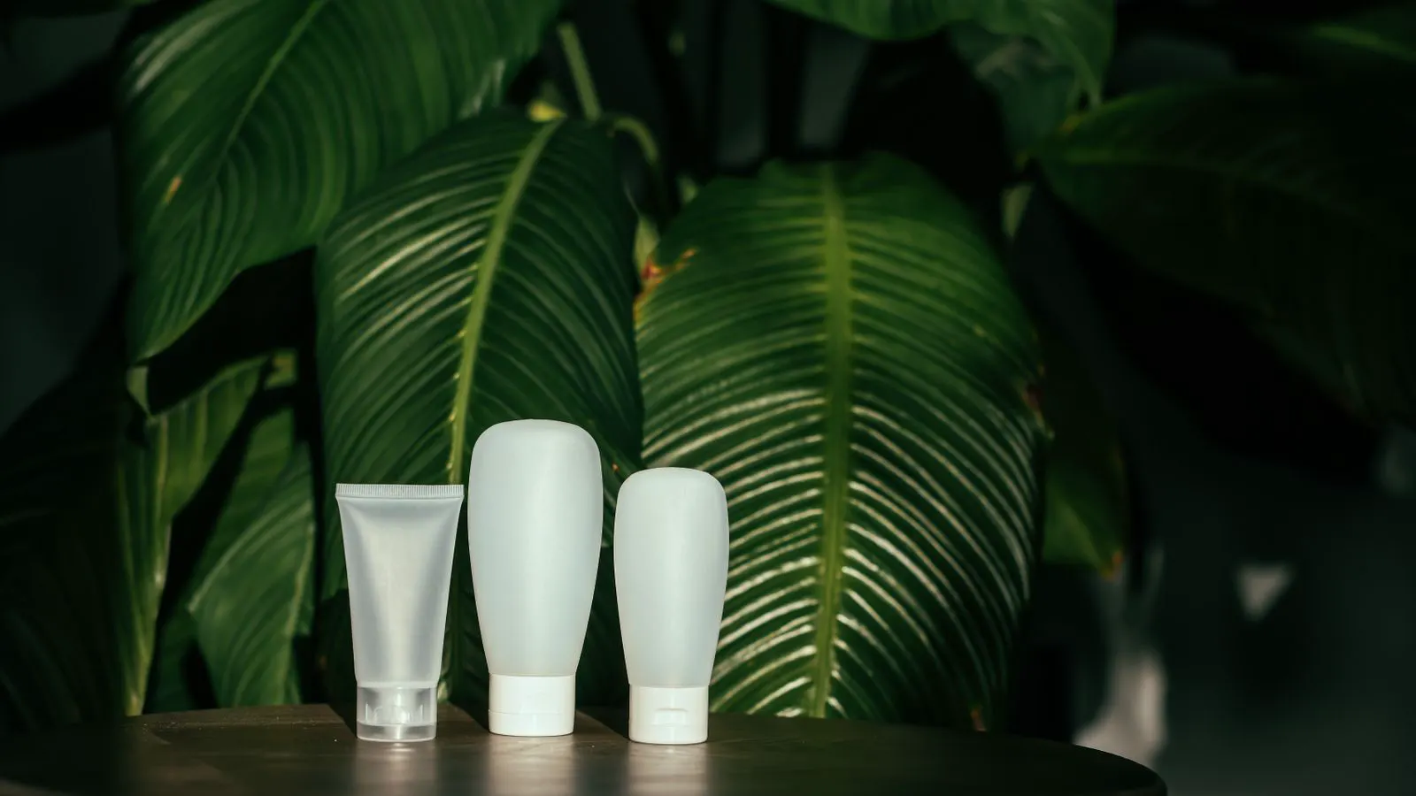 A display of recyclable cosmetic jars and refillable pump bottles on a table.