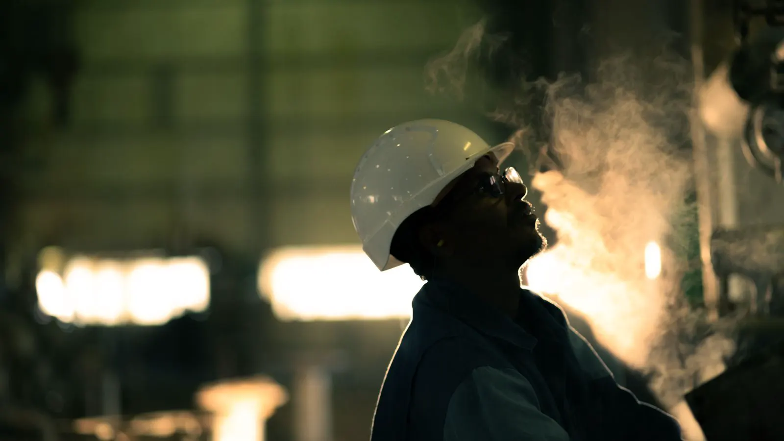 Technician inspecting air compressor piping in a factory