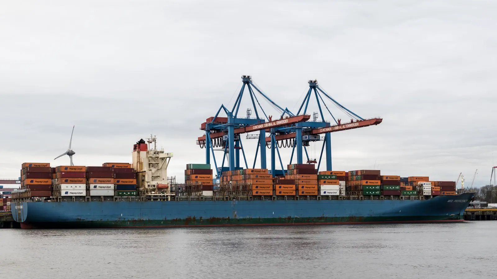A large shipping container with an industrial air compressor inside.