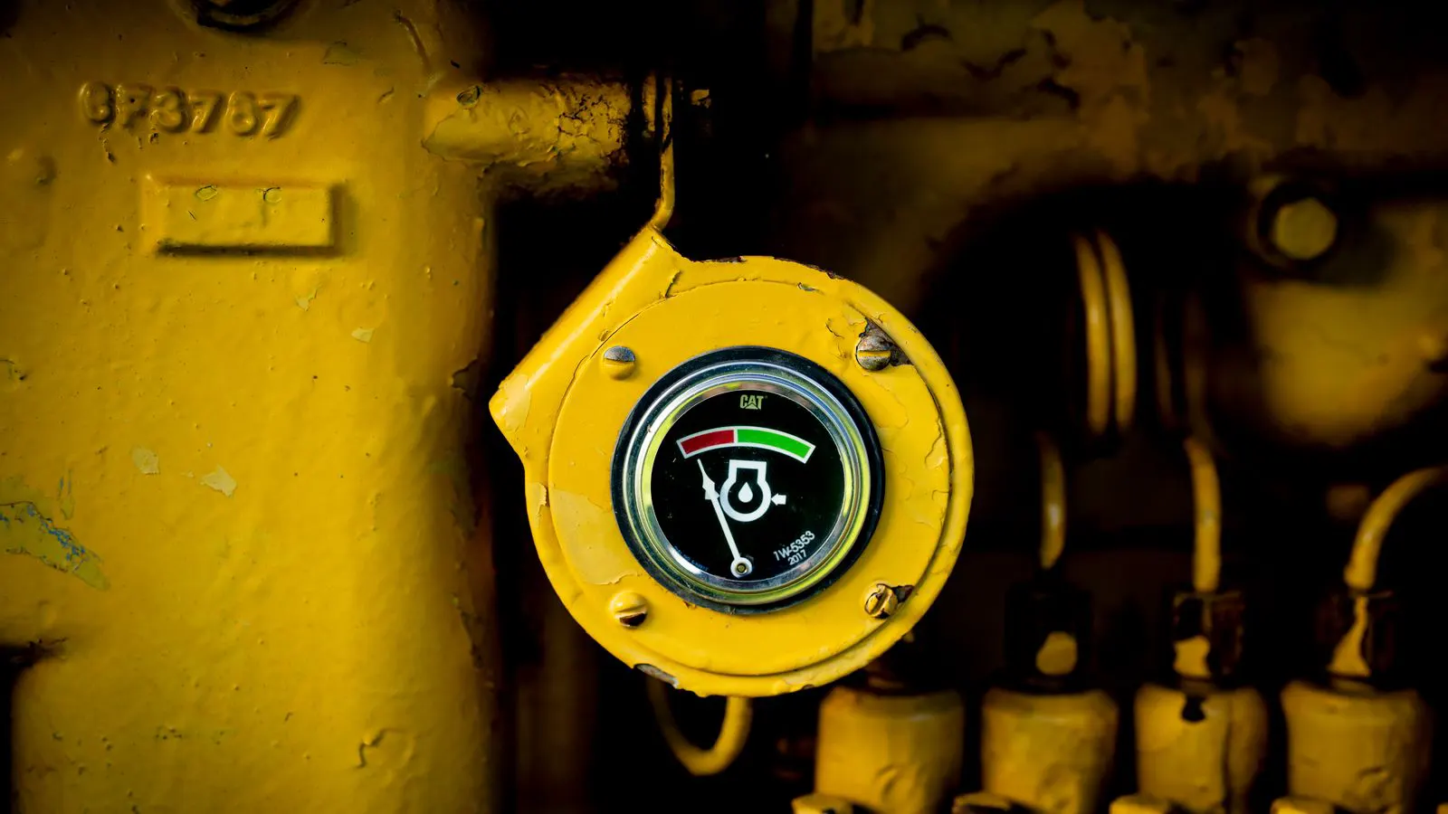 Technician checking pressure gauge on a screw compressor