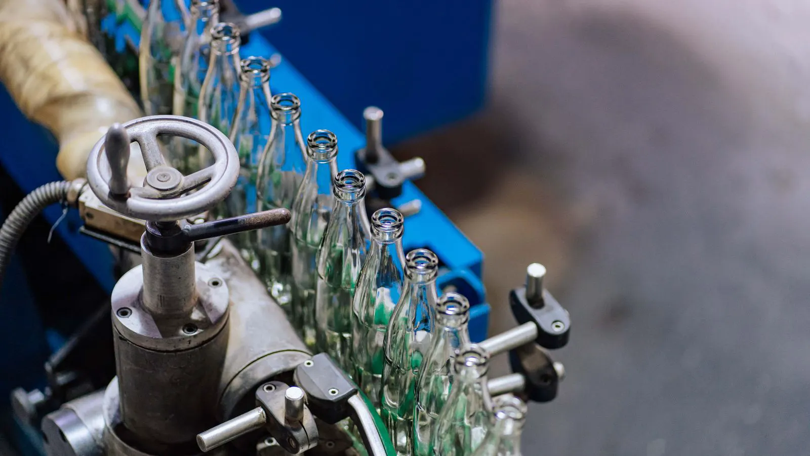 A row of fans attached to a metal frame near a production line