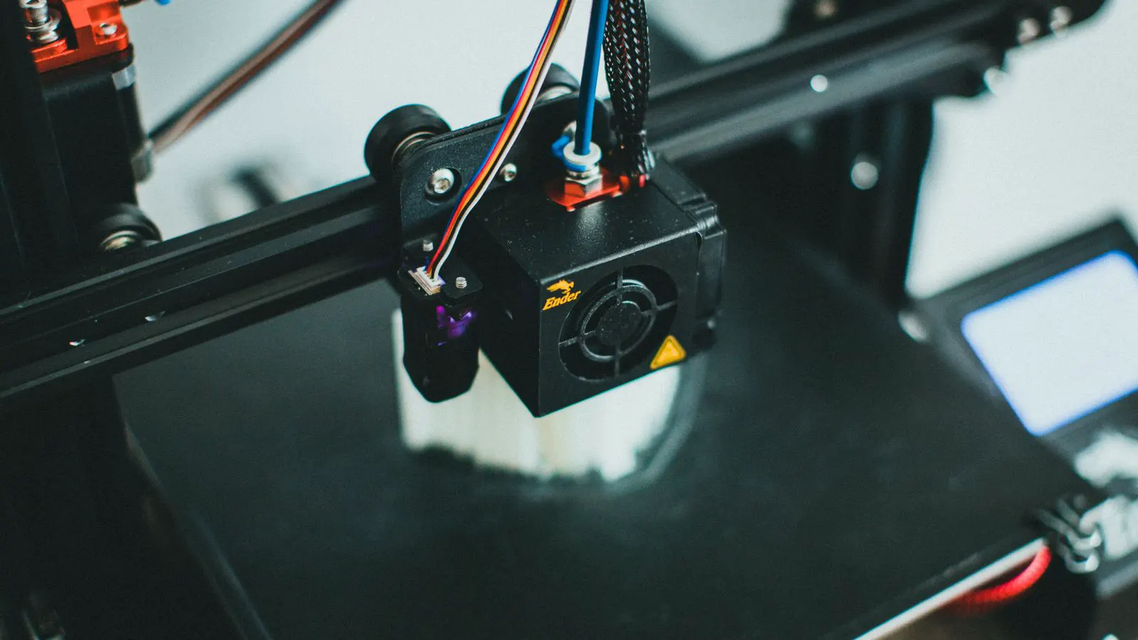 A close-up view of a plastic extrusion die head with cooling channels.