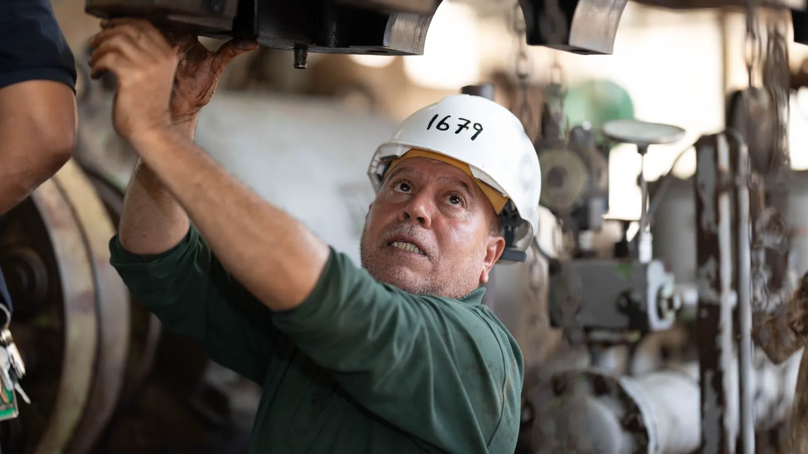 A technician checking the control panel of an industrial machine.
