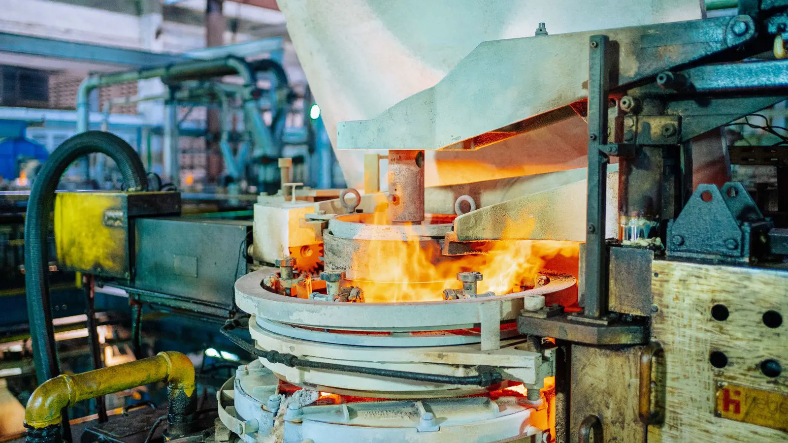 A large industrial blow molding machine processing plastic preforms in a production facility