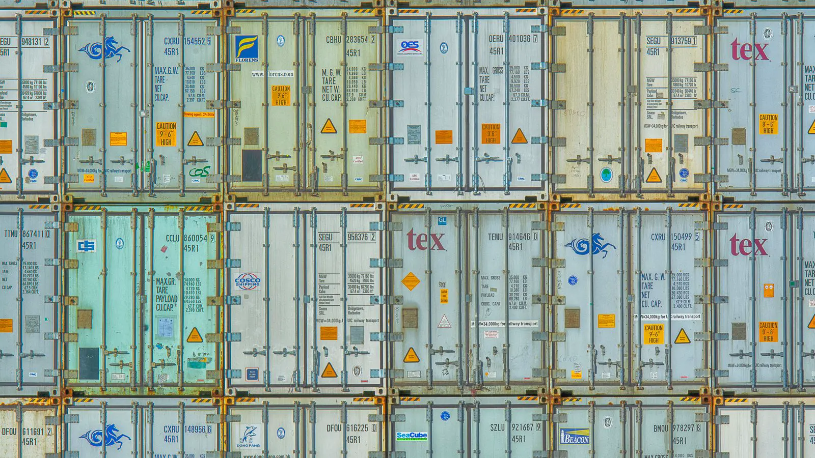 Shipping containers stacked in a large industrial warehouse facility
