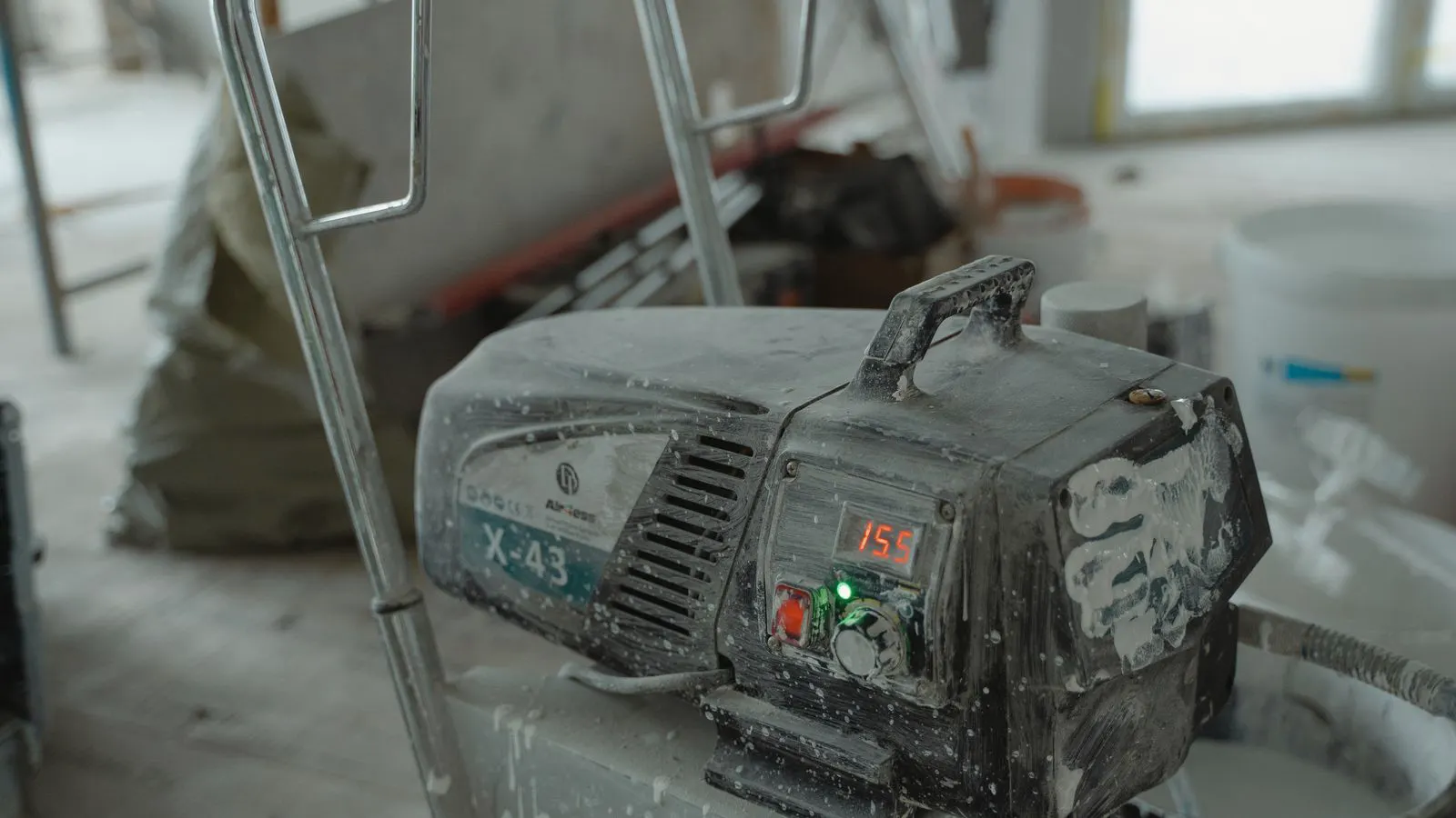 A large plastic dryer hopper connected to an air compressor unit.