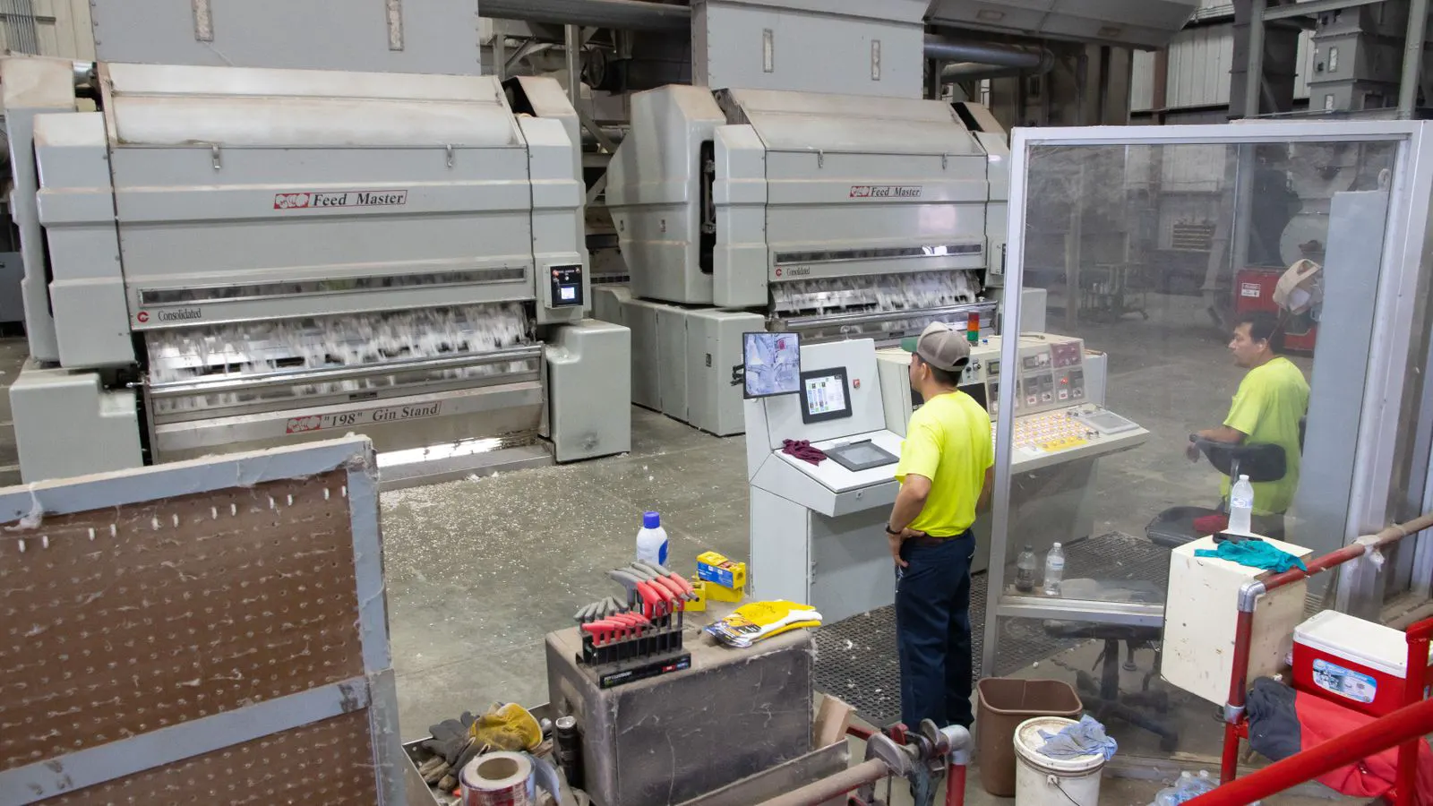 Two injection molding machines on a factory floor with control panels
