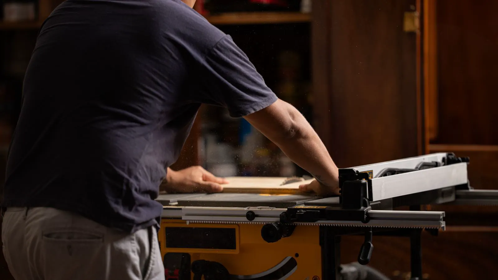 Close view of a blade guard on a table saw with fence and workpiece