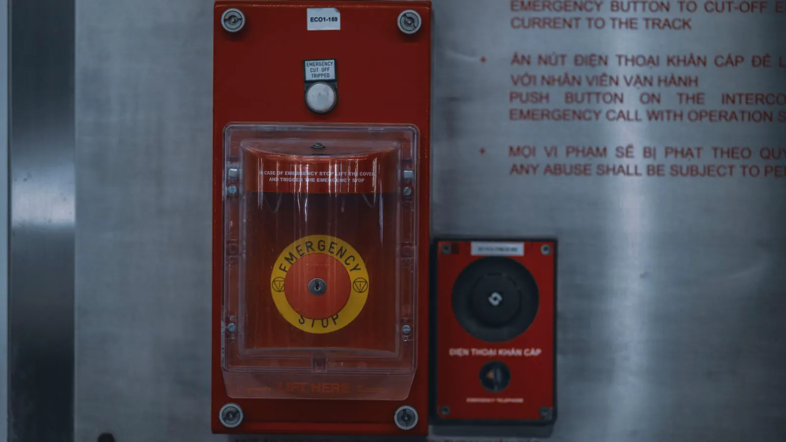 Close up of an industrial saw control panel with red emergency stop button