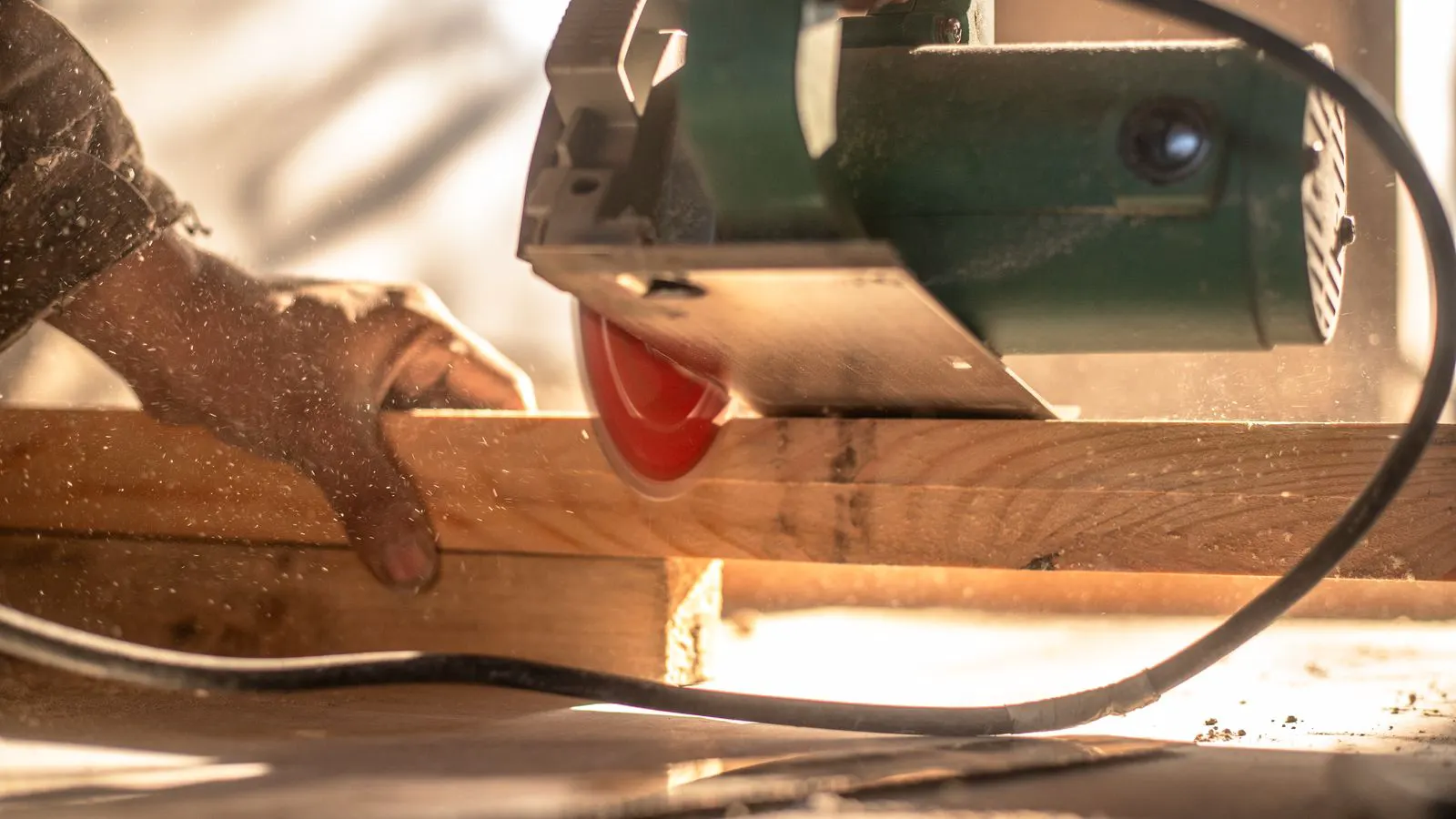 A professional inspecting a circular saw blade mounted on an industrial table saw.