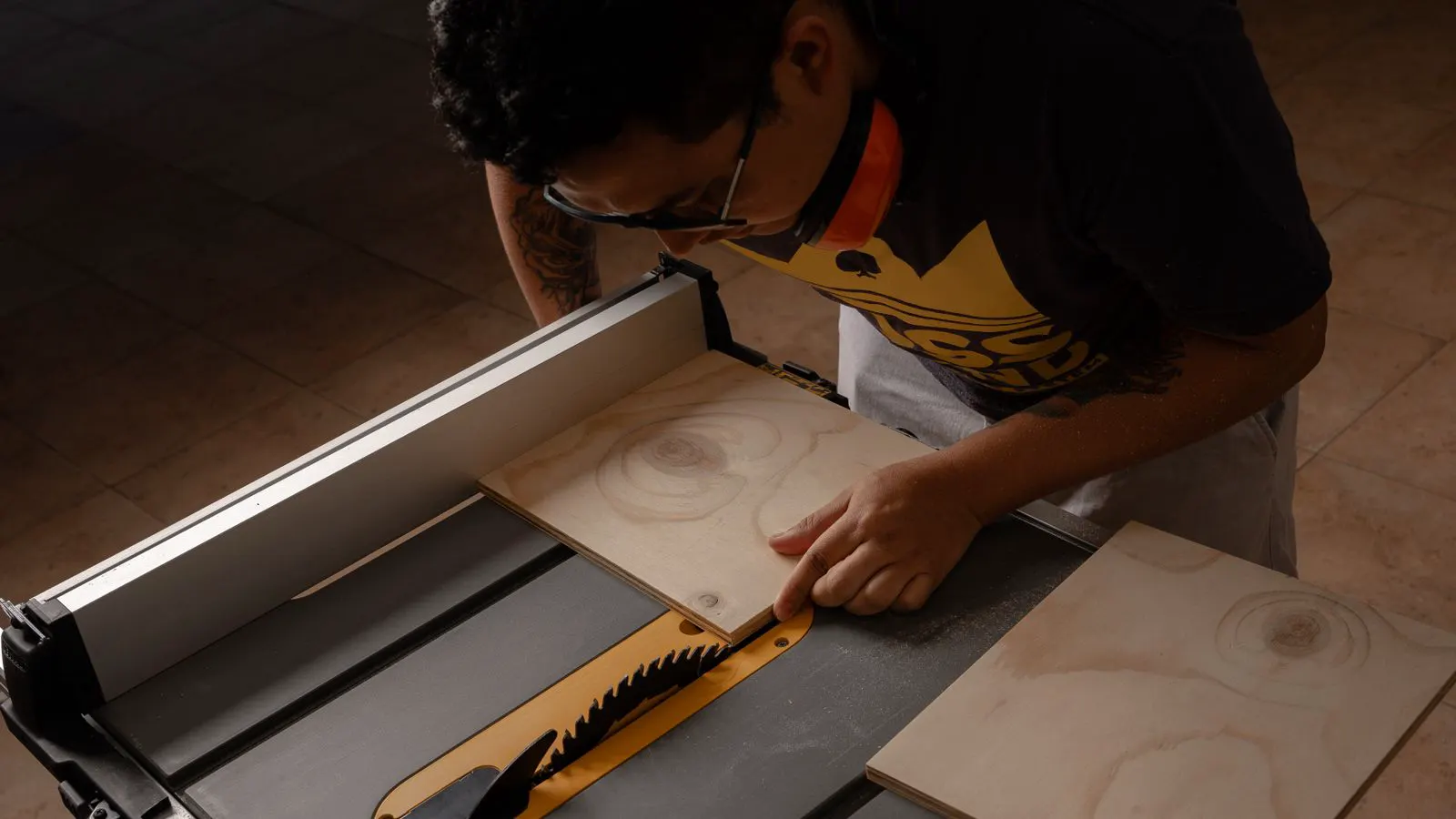A professional woodworking shop floor with a large industrial saw