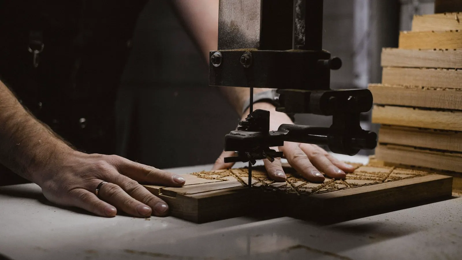 A professional woodworker operates a dust collection system in a workshop.