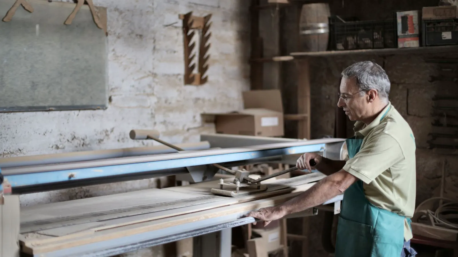 A woodworking operator guiding a panel through an edge bander station.