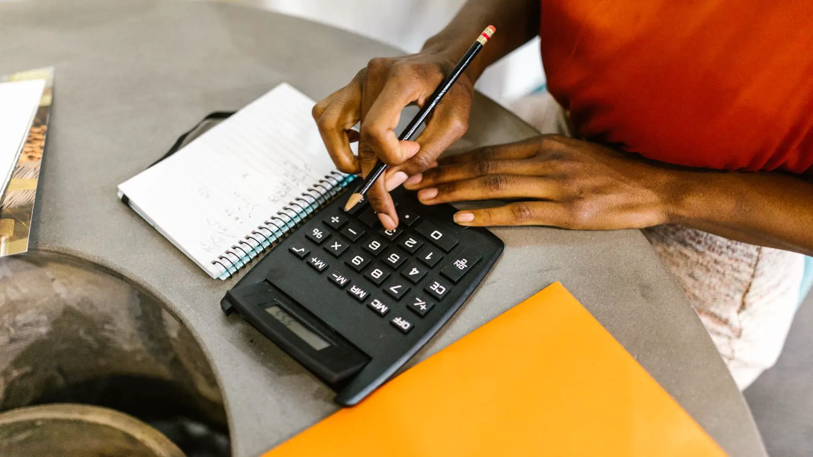 A manager reviewing machinery purchase documents and budget spreadsheets at a desk.