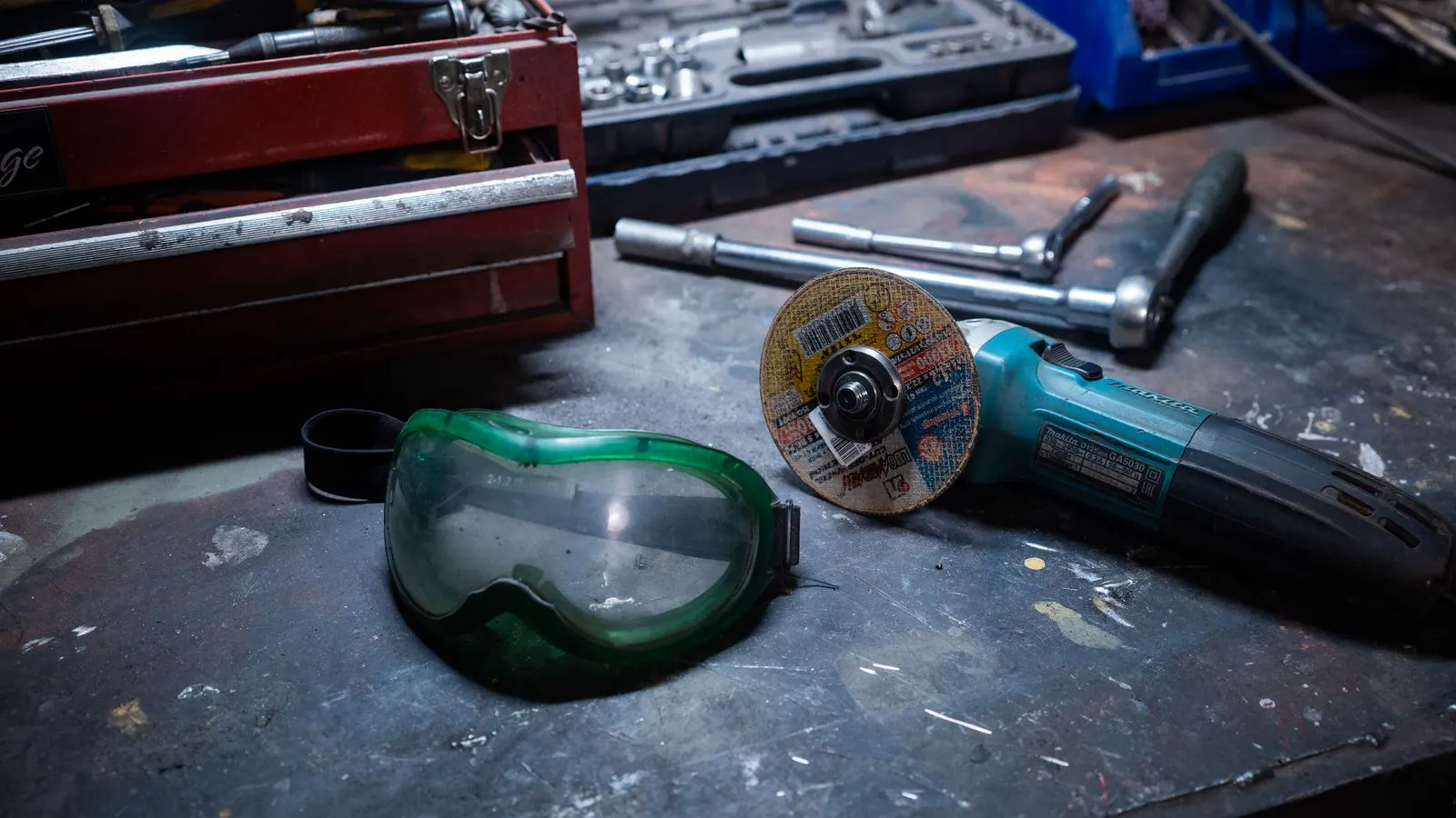 A worker wearing certified safety gear near a machine in a workshop