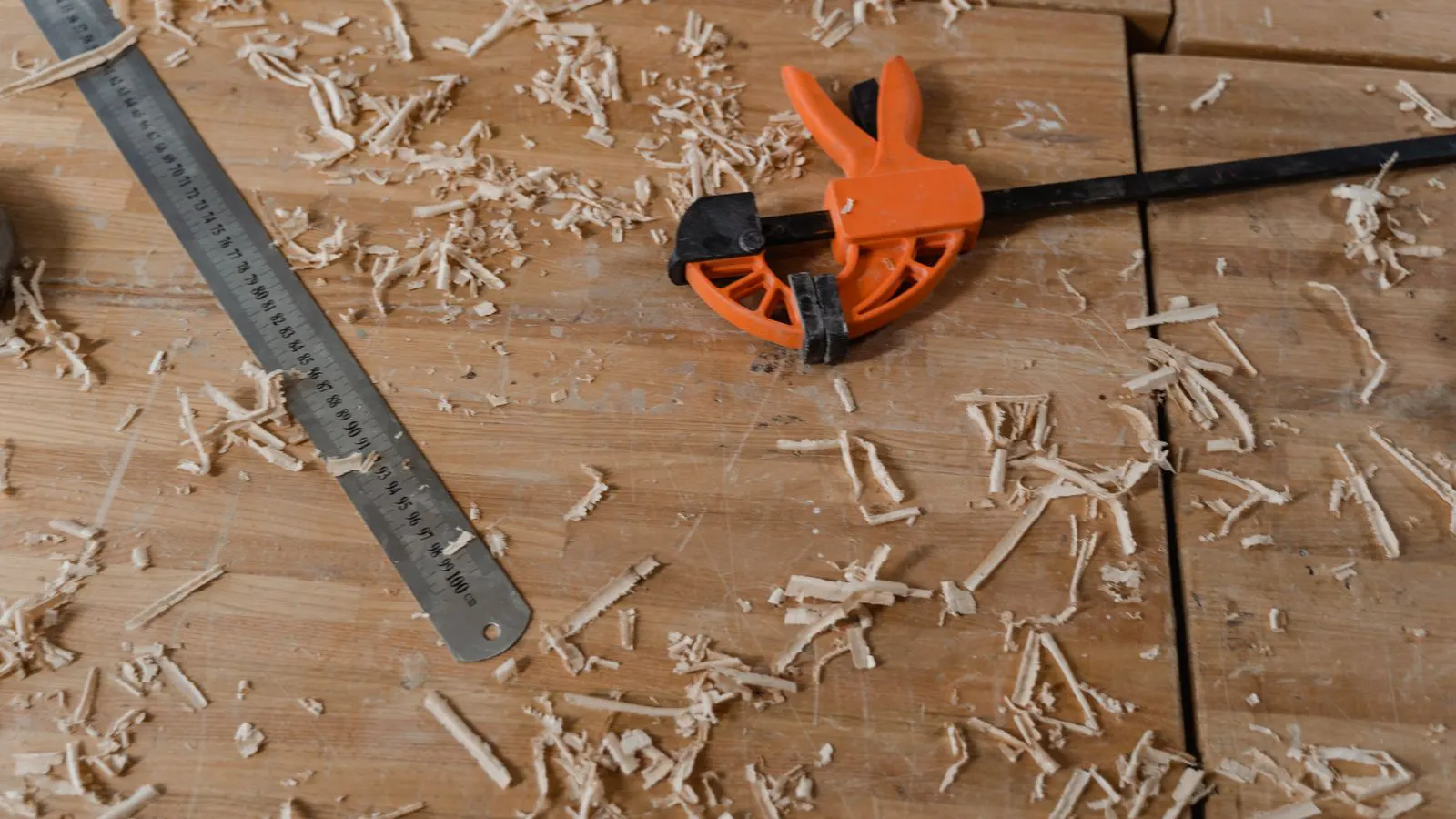 A clean workbench with a small woodworking machine and clamps
