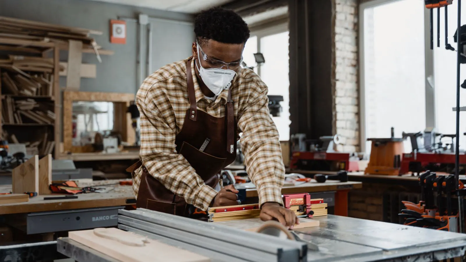 A worker wearing protective gear observing a machine guard during a training session