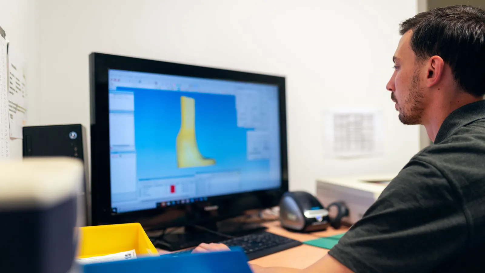 An engineer checks part geometry and tool paths on a computer screen.