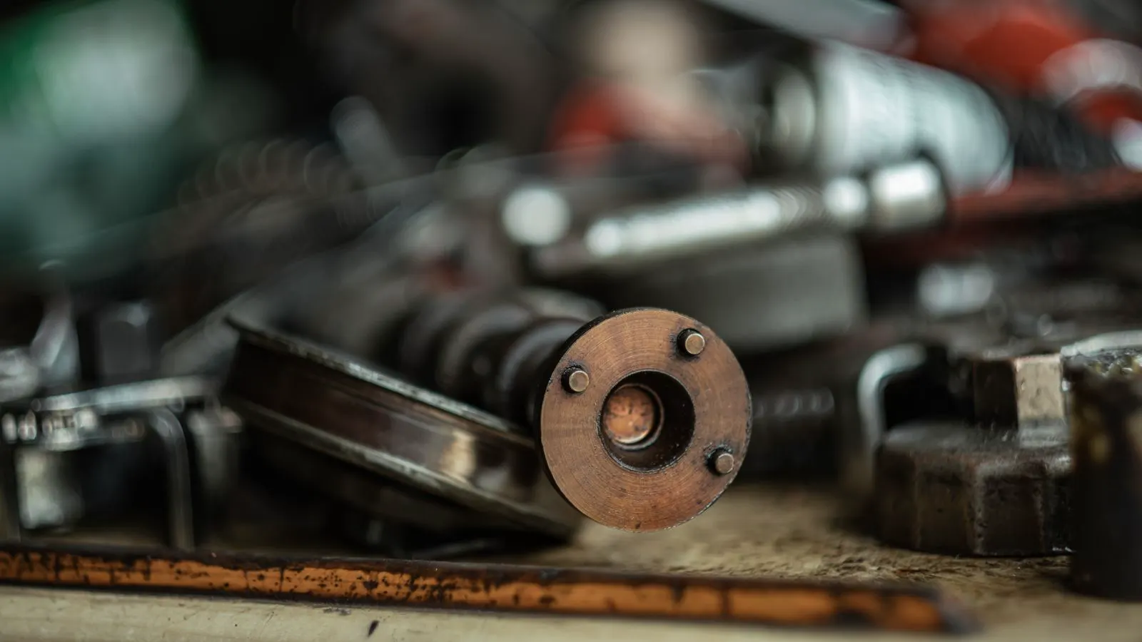 A precision metal part resting on a inspection bench with a digital caliper nearby