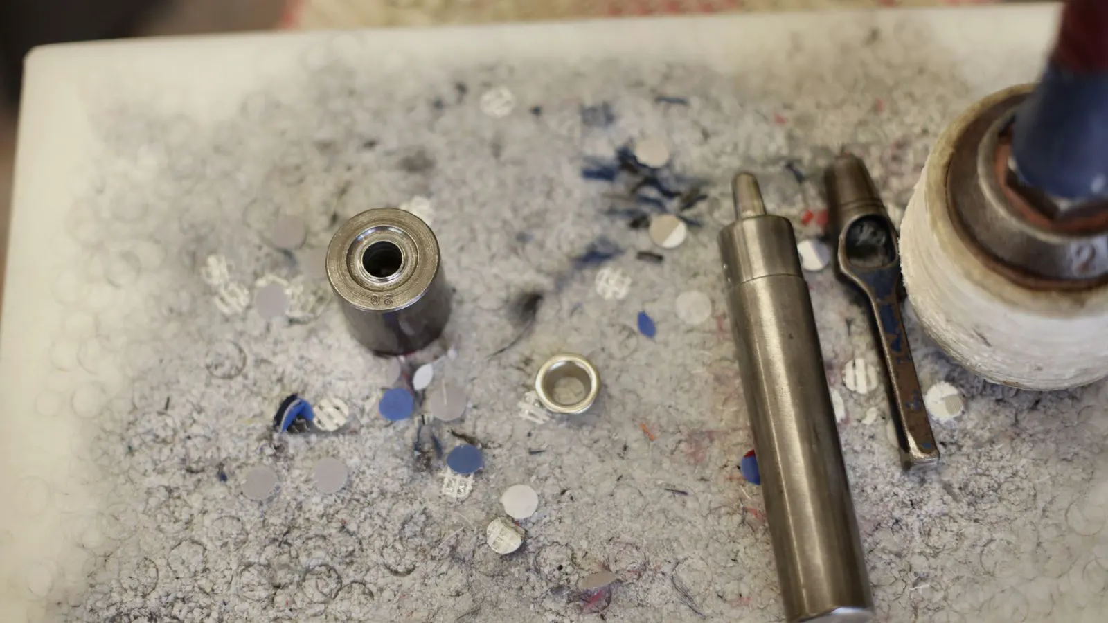 A machined hardened steel part sits on a granite inspection table.
