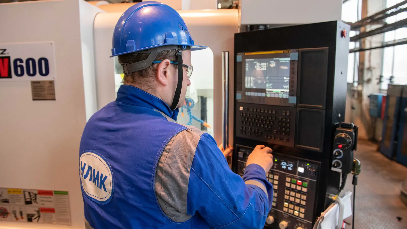 An engineer inspecting a precision machined part on a machine tool.
