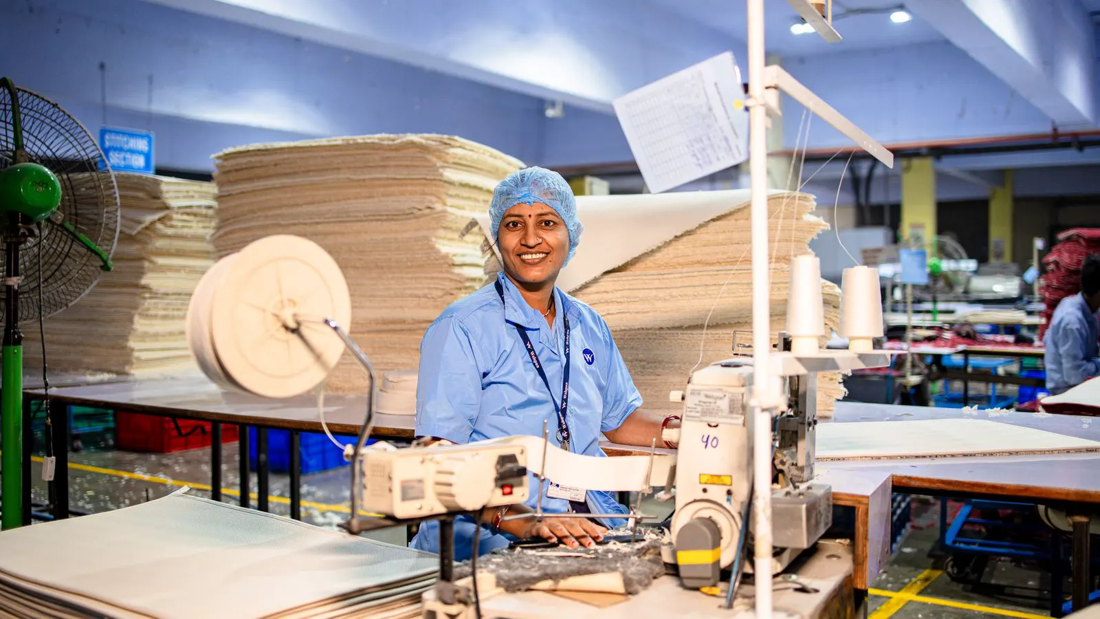 A technician checks a loom control panel during a maintenance pause.