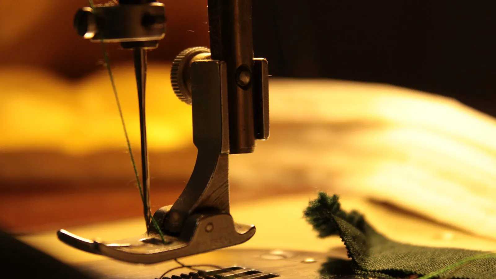 Close up of single and twin needle assemblies on industrial sewing machine