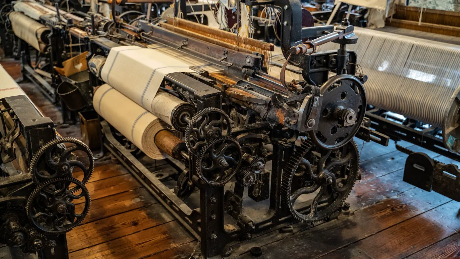 Technician inspecting a power loom in a textile factory