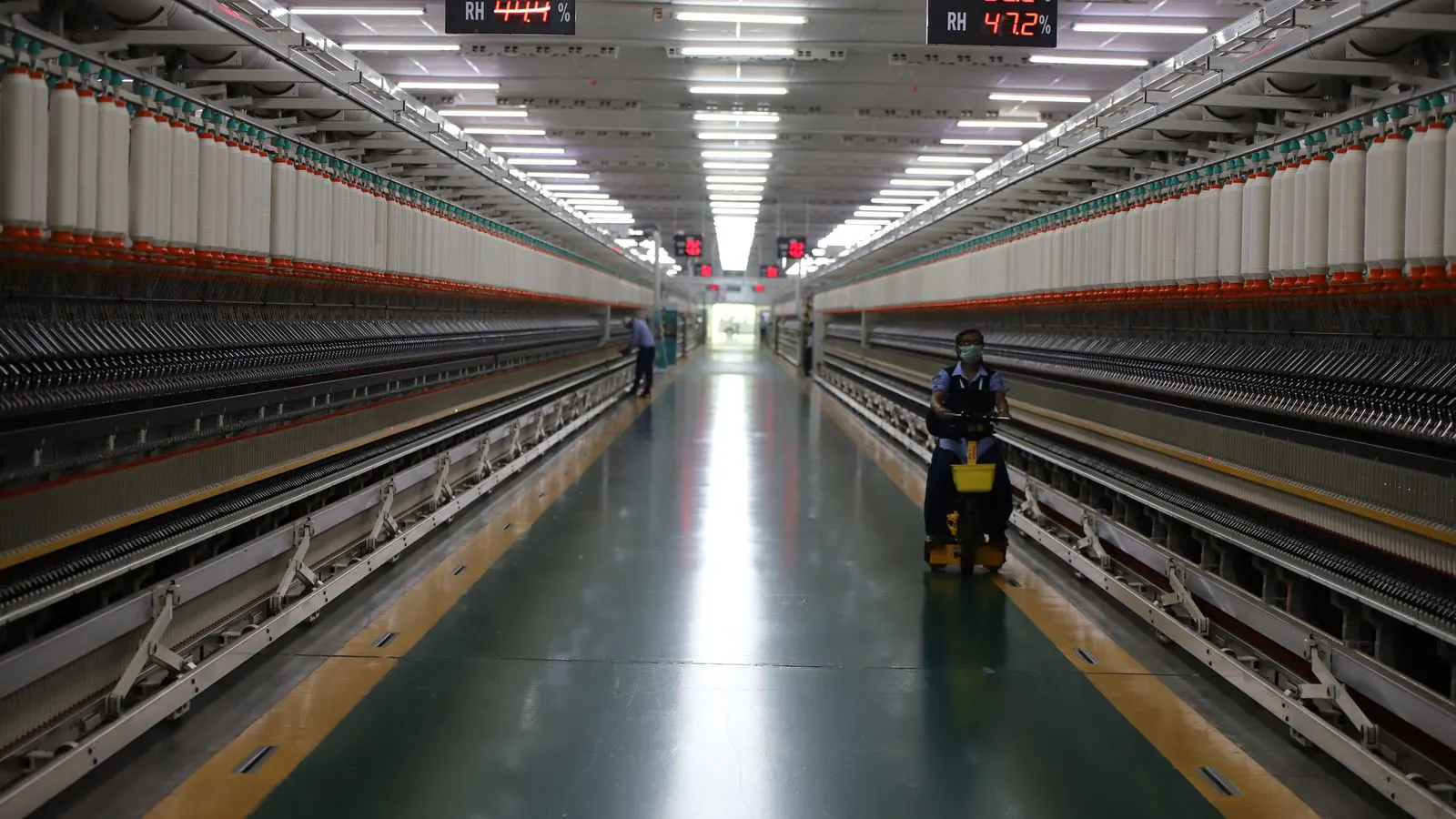 Modern textile spinning machines arranged in a large industrial facility.